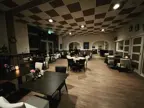 De binnenkant van Visrestaurant De School. Het heeft een geruit plafond, houten vloeren.